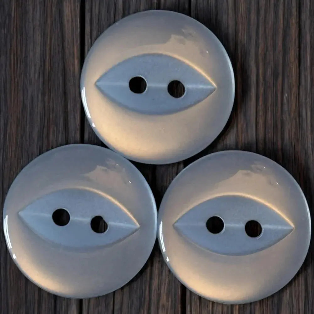 Three shiny, gray, two-hole buttons.