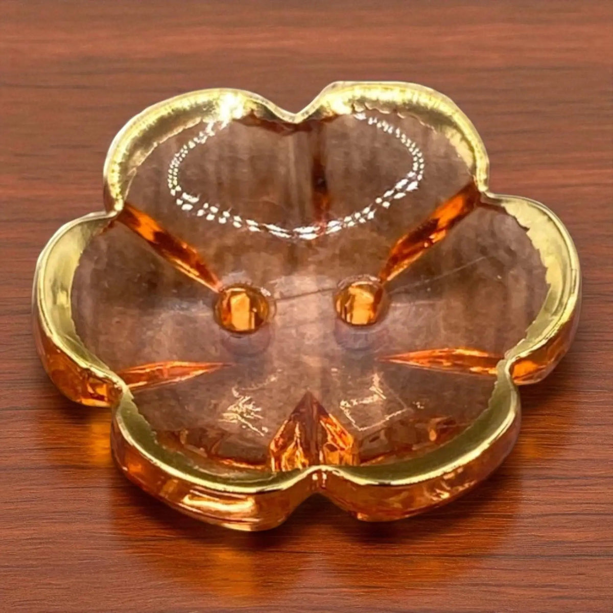 KnitForLess 13mm baby blue flower-shaped acrylic button with a gold rim and two-hole design on a wooden surface