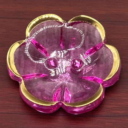 KnitForLess 13mm baby blue flower-shaped acrylic button with a gold rim and two-hole design on a wooden surface