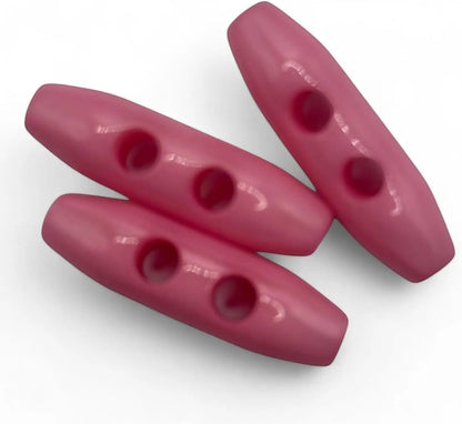 KnitForLess baby pink plastic toggle buttons with a 38mm oval shape and 2-hole design for sewing projects