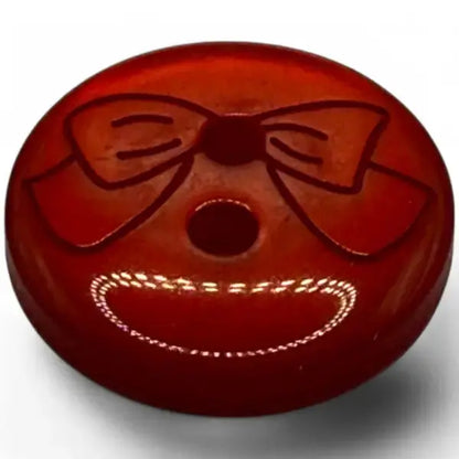 Red button with a bow and smile.