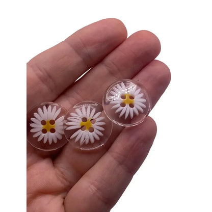 Three daisy-themed clear buttons.