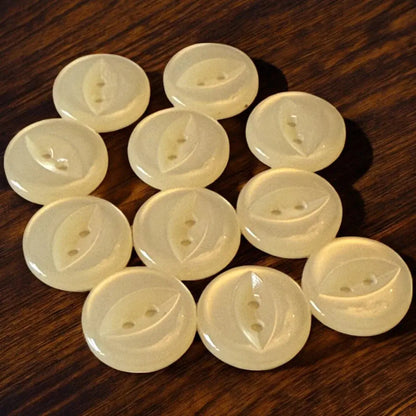 Collection of pale yellow, round buttons with leaf design.