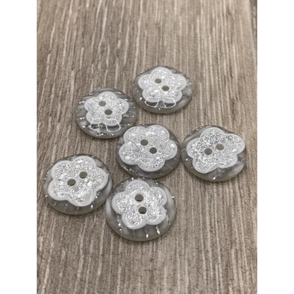 Six flower-shaped glittery buttons.