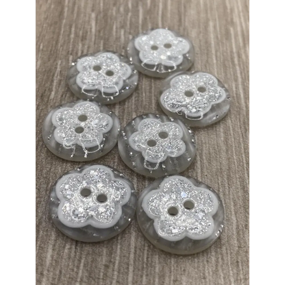 Seven flower-shaped glittery buttons.