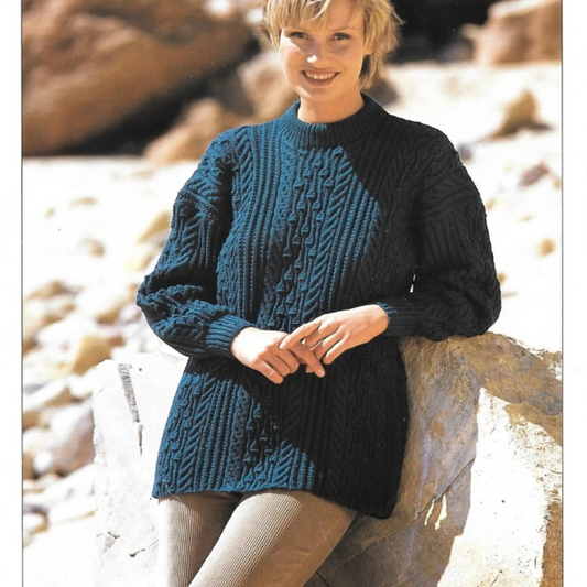 KnitForLess Hayfield DK sweater pattern featuring a woman wearing a dark teal cable-knit wool sweater outdoors.