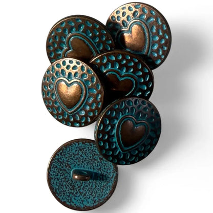 Pile of heart-stamped, turquoise-accented, bronze buttons.