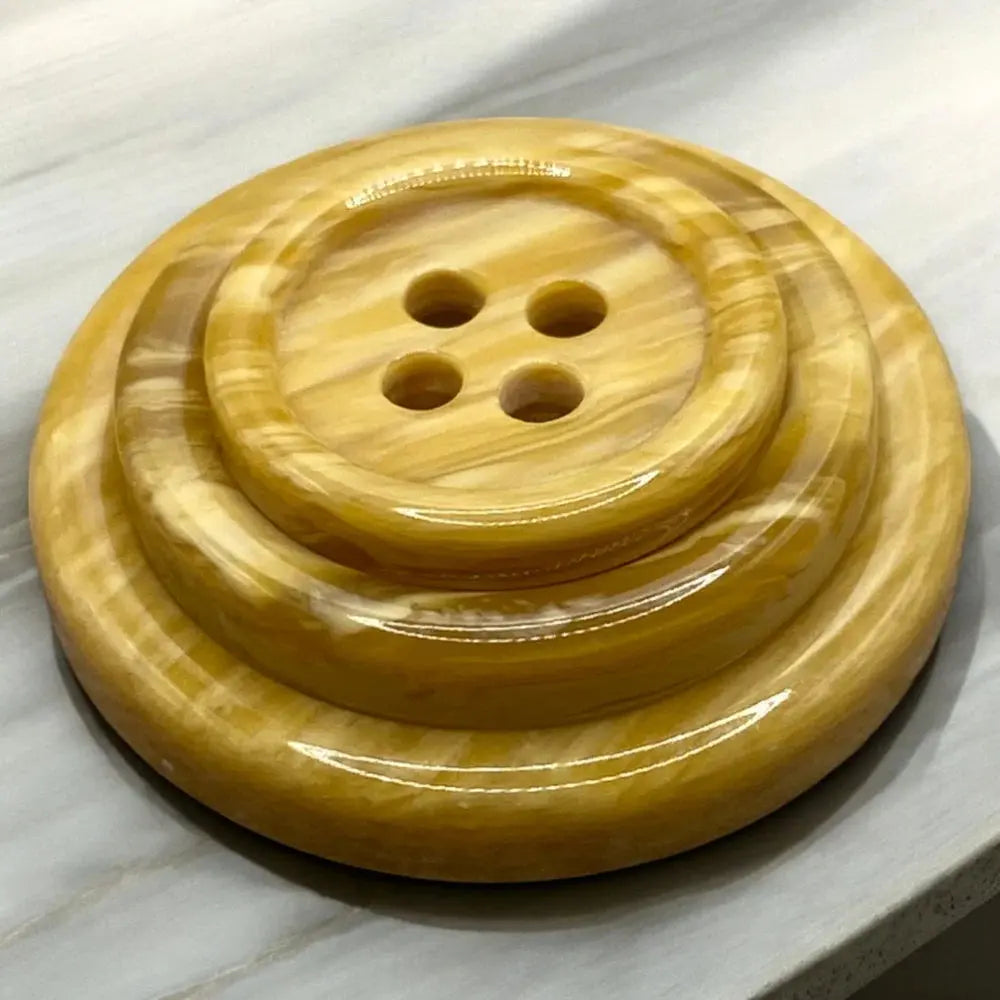 Shiny, layered, four-hole button.