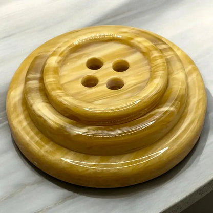 Shiny, layered, four-hole button.