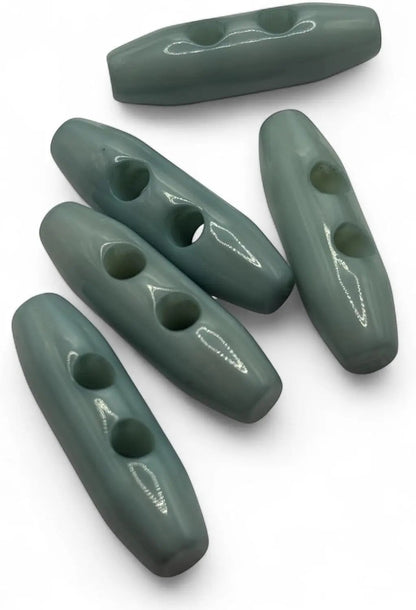 KnitForLess light blue toggle buttons with a smooth glossy finish and two holes for sewing onto knitwear and coats.