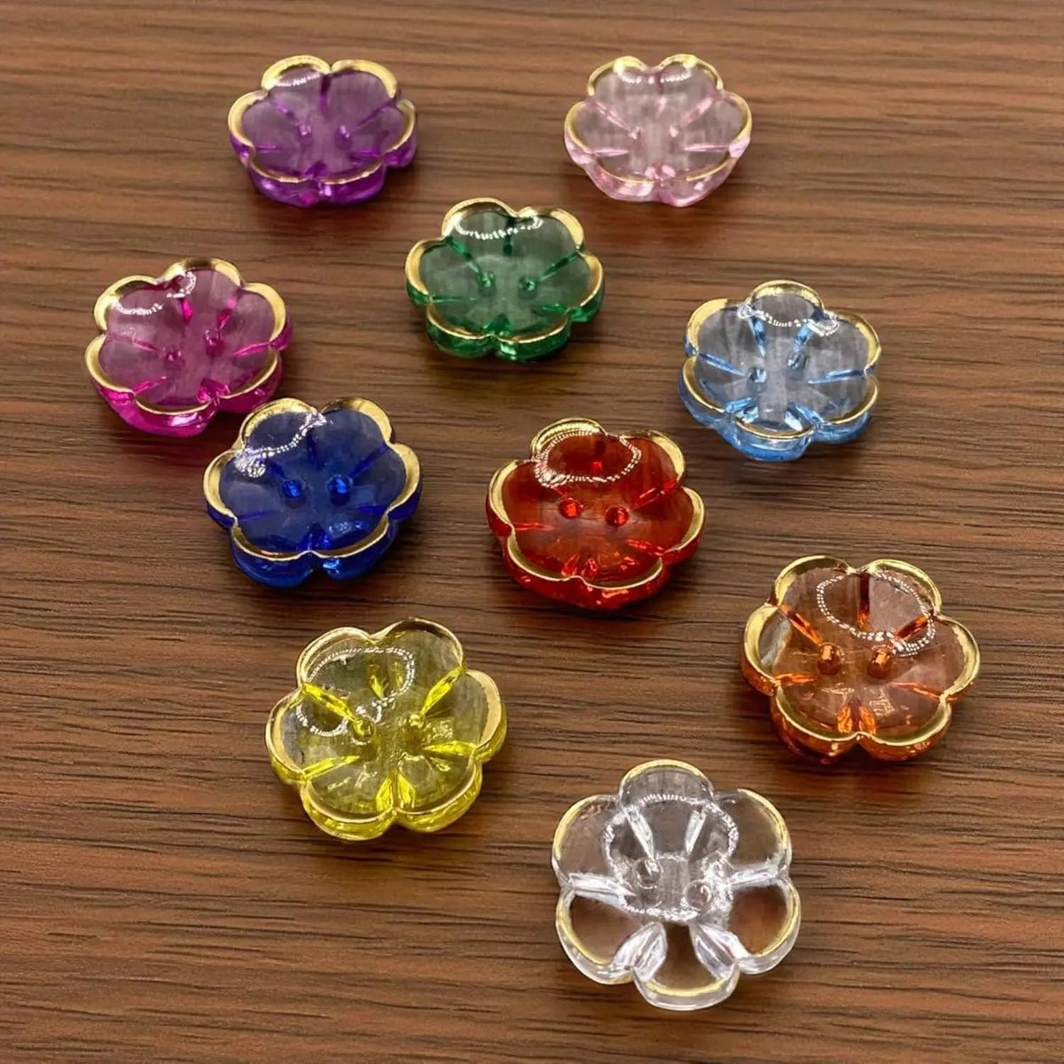 KnitForLess multi-colored flower-shaped acrylic buttons with gold rims, 13mm 2-hole craft buttons on wood surface