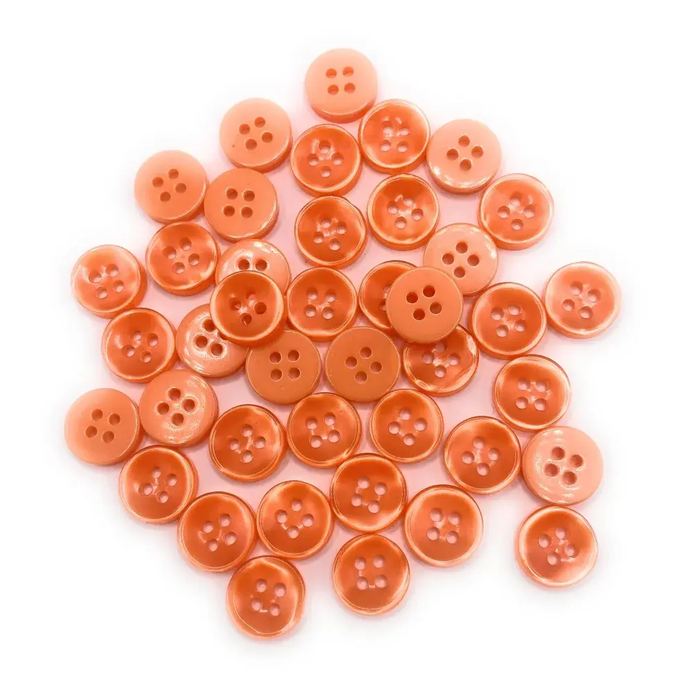 Pile of peach-colored sewing buttons.