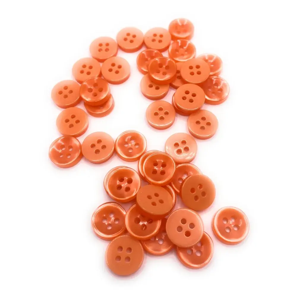 Pile of orange four-hole buttons.