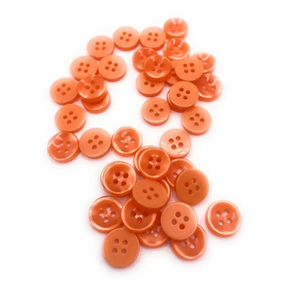 Pile of orange four-hole buttons.