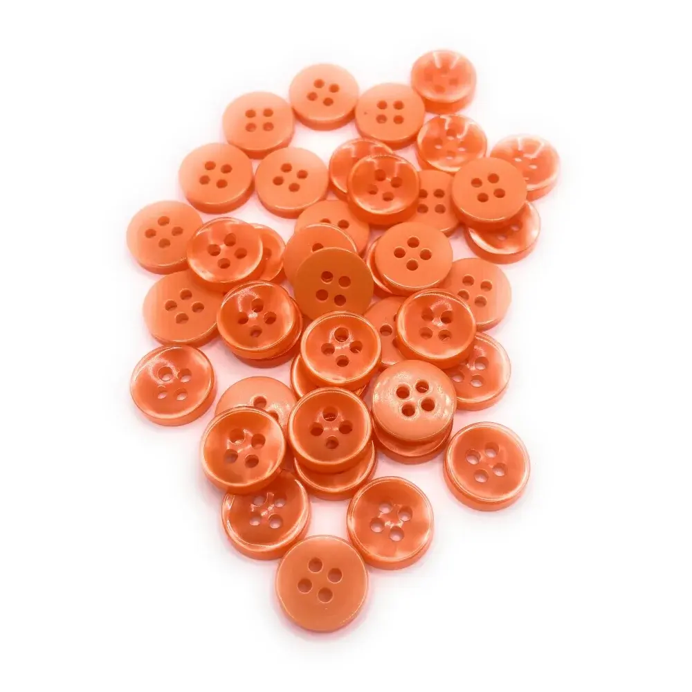 Pile of orange four-hole buttons.