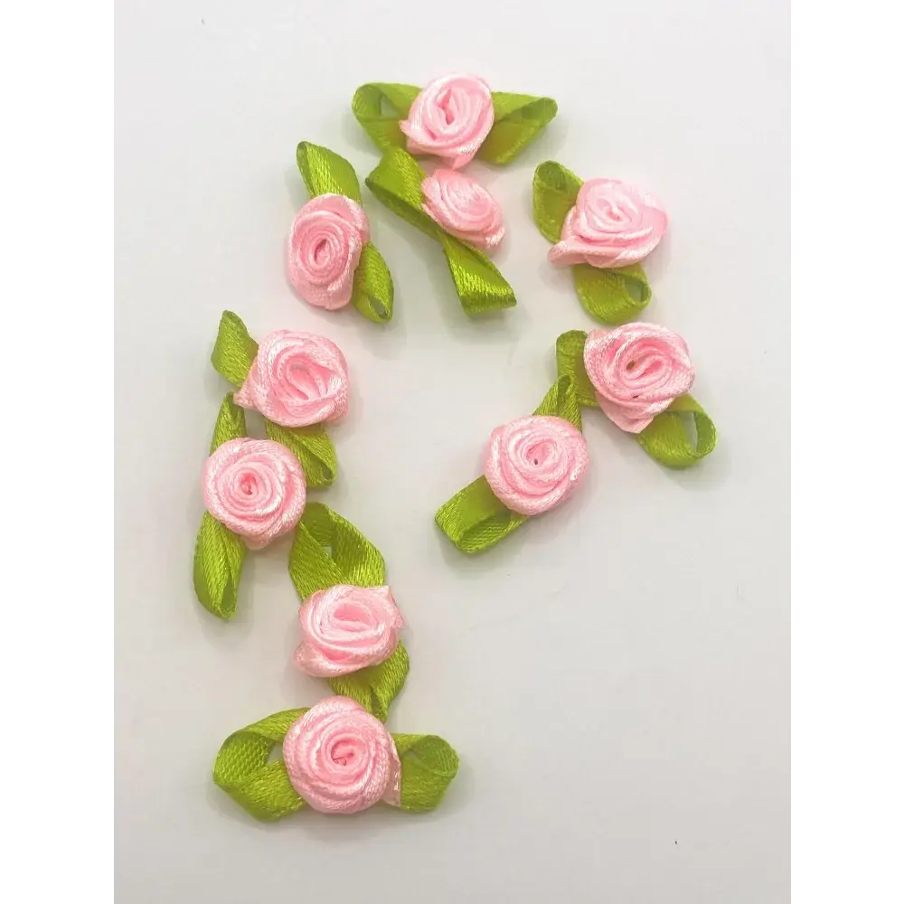 Pink ribbon roses with green leaves.
