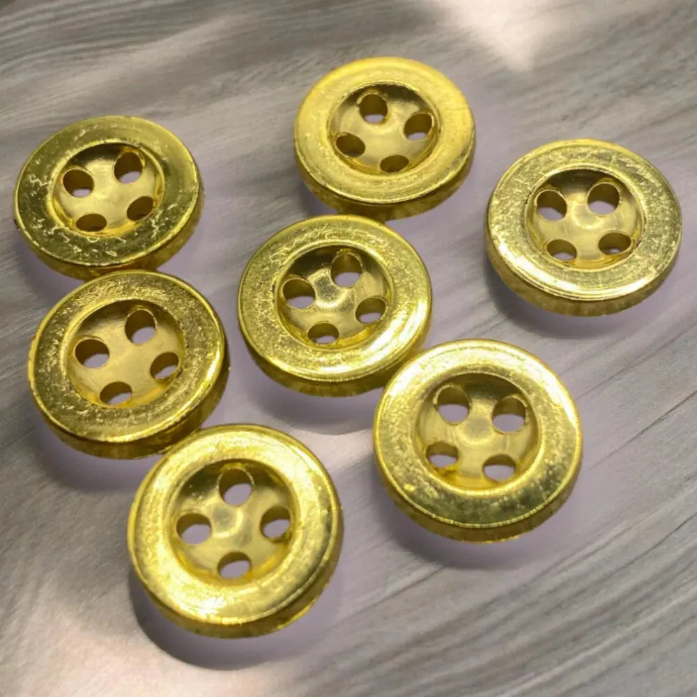 Seven gold-colored buttons with five holes.