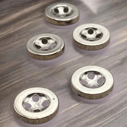 Shiny silver buttons with multiple holes.