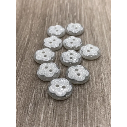 Flower-shaped, glittery, gray buttons.
