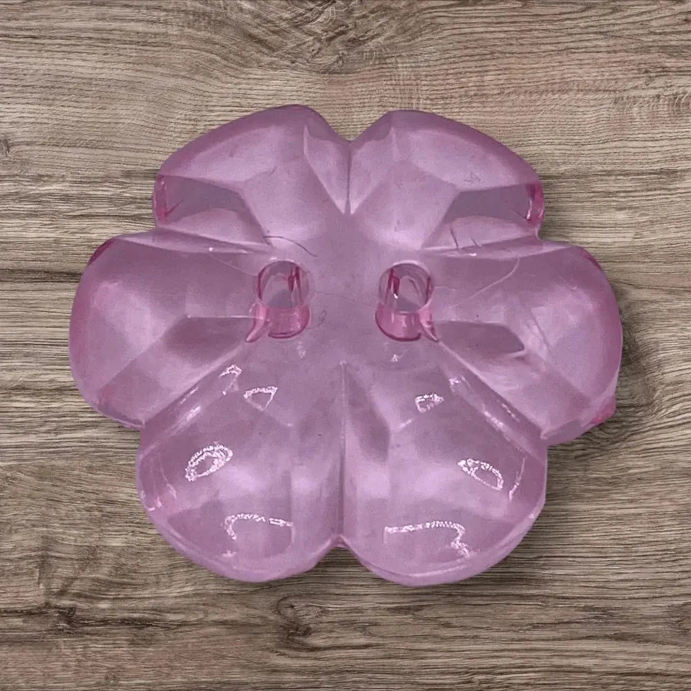 Translucent pink flower-shaped button.