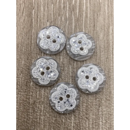 Five flower-shaped glittery buttons.