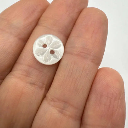 Round, flower-engraved, two-hole button.