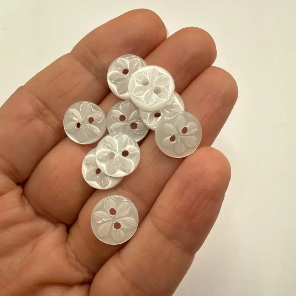 Handful of white flower-patterned buttons.