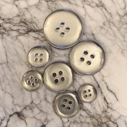 Silver-colored, four-hole buttons.