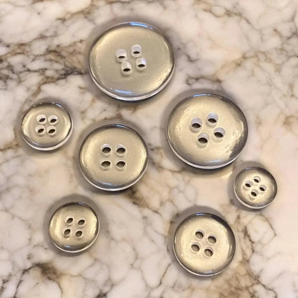 Assorted silver-colored buttons.