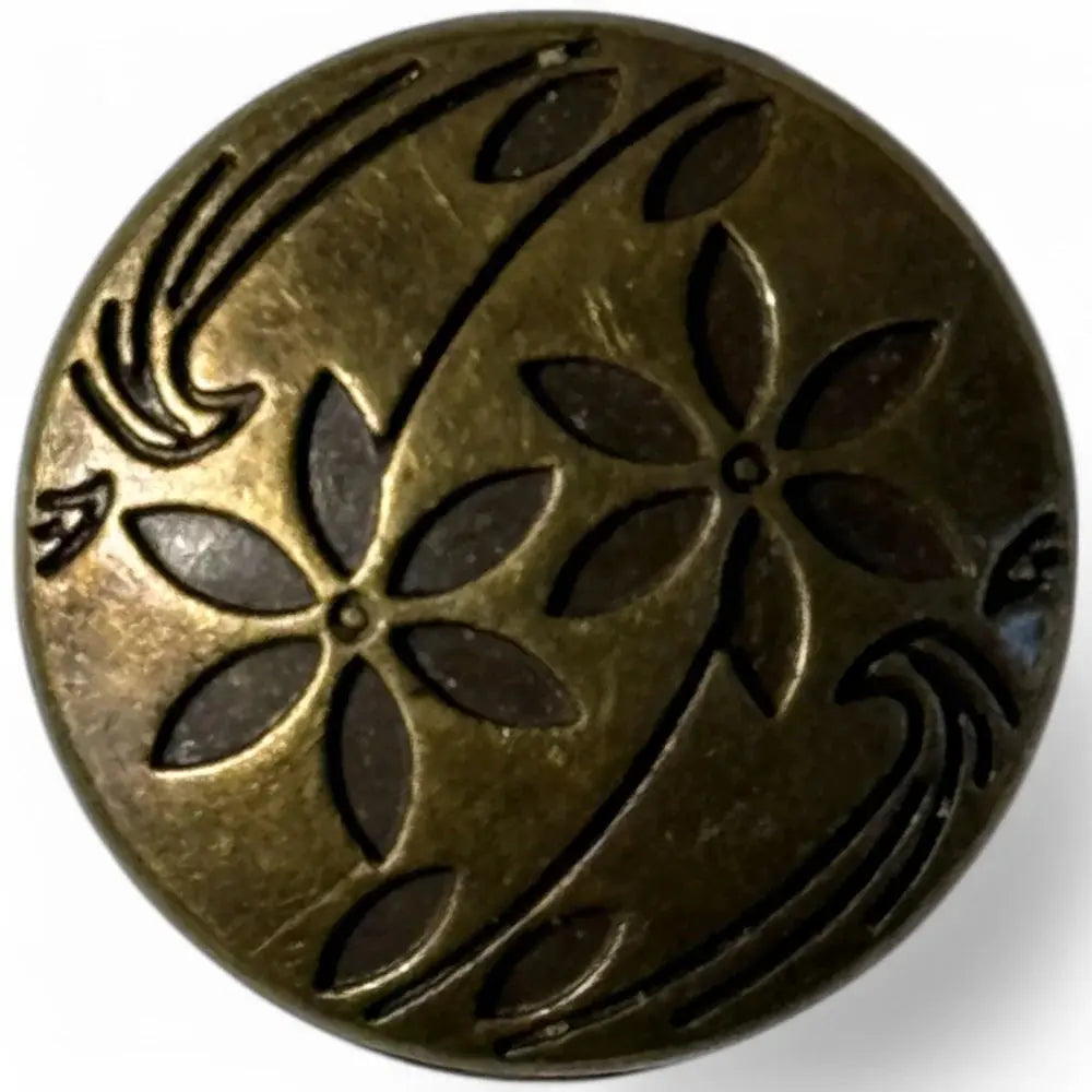 Circular bronze-toned button with floral design.