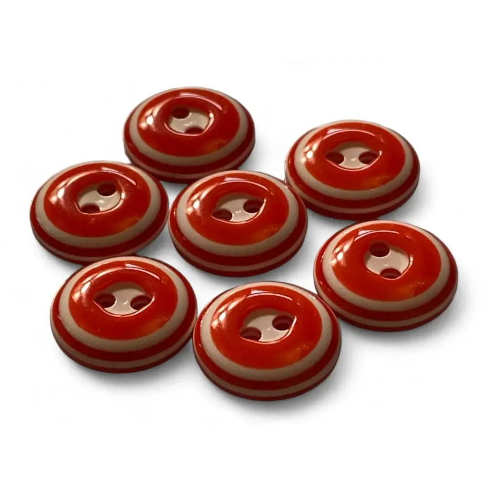 Seven red and beige striped buttons.