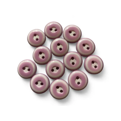 Pile of mauve two-hole buttons.